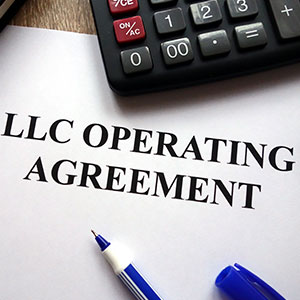 LLC operating agreement document with a pen and calculator.