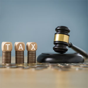Estate planning with tax refund coins, TAX blocks, and gavel highlight financial decisions.
