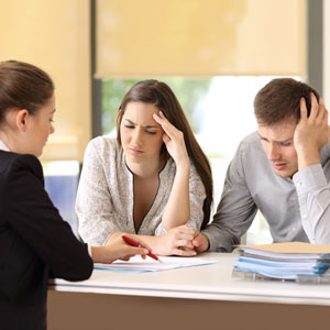 Couple consulting lawyer about joint vs. separate tax returns in office setting.