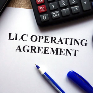 LLC operating agreement document with a pen and calculator.
