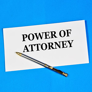 A POWER OF ATTORNEY document with a pen, on a blue background.
