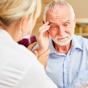  A caregiver assisting an elderly man with dementia, representing the need for guardianship. 