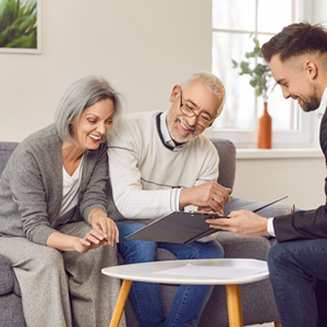 Financial advisor discussing estate planning documents with happy, aging parents in South Carolina.