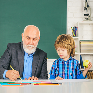 Senior male teacher working with a young student, related to retirement and legal considerations for South Carolina Teachers.
