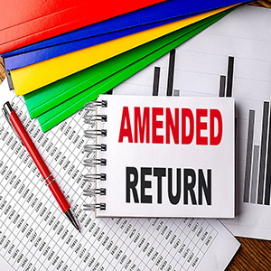 Notepad with Amended Return text on tax documents for IRS filing and audit prevention