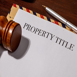 Property title document with judge's gavel and pen for estate plan asset alignment.