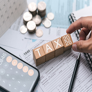 2026 IRS Tax Strategy: Hand placing "2026 TAX" blocks on IRS Form 1040 for South Carolina families.