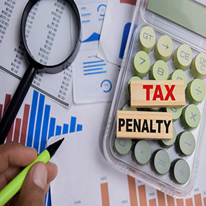 A red "Tax Penalty" stamp over a 1040 tax form with a calculator and pen nearby.
